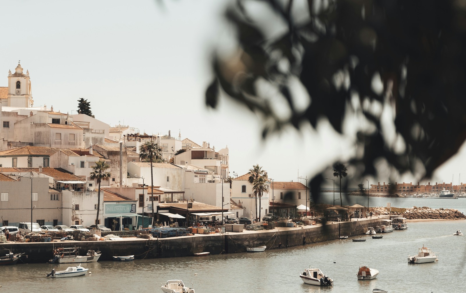 Coastal town and boats beside calm water in Ferragudo, Portugal